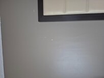 Peeling paint on wall in the room right by the bed.