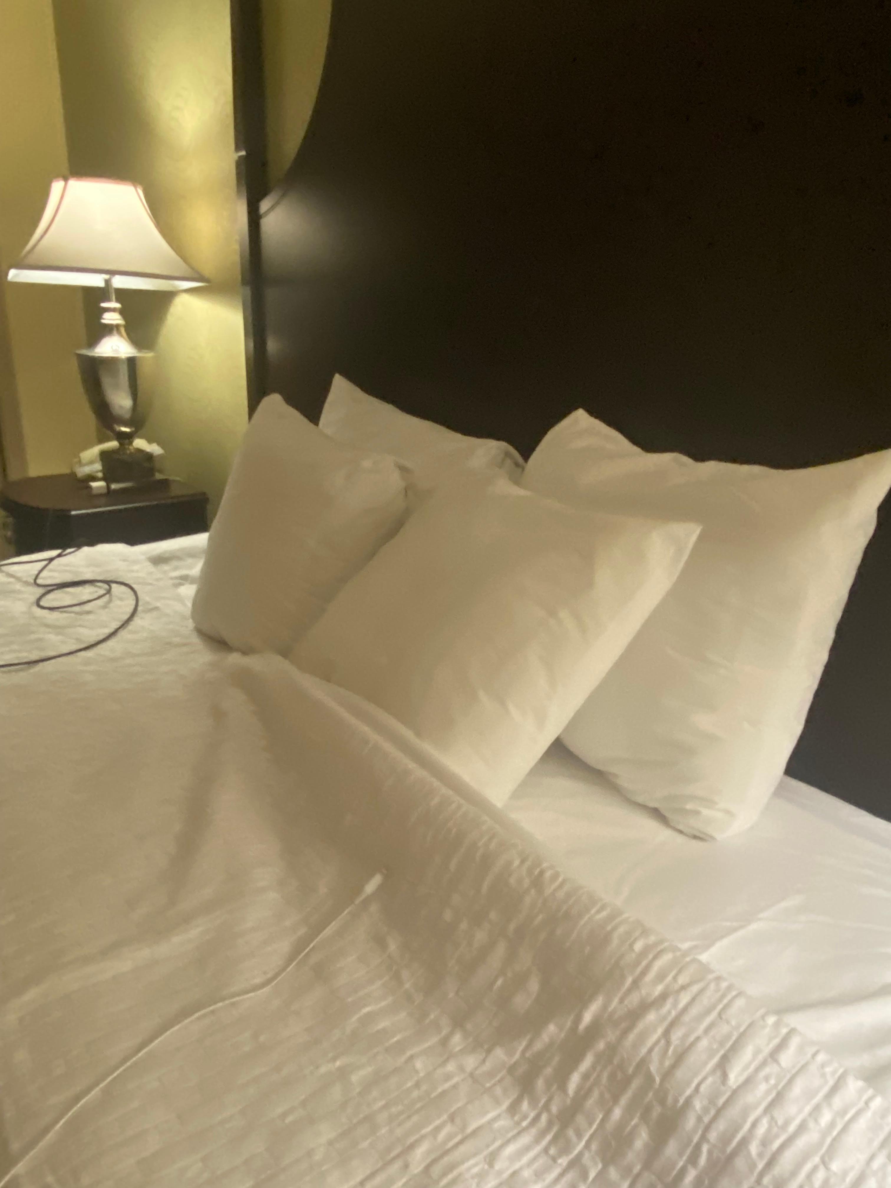 Four tiny pillows on king size bed, and not very white