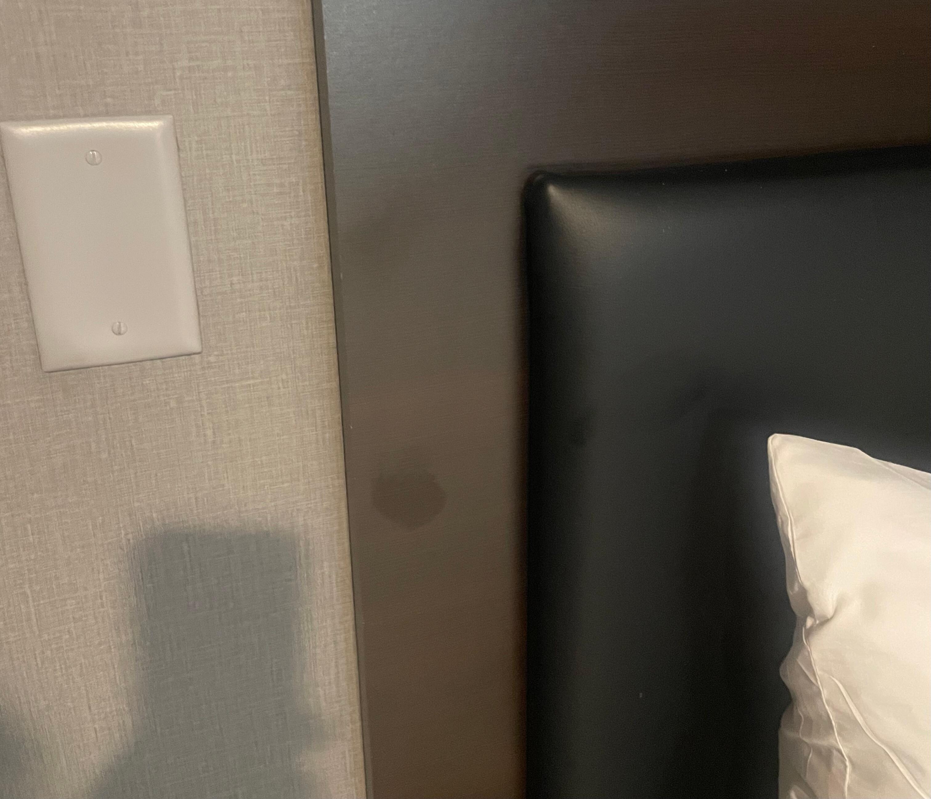 Some type of stain left on headboard right next to butt mark on bed