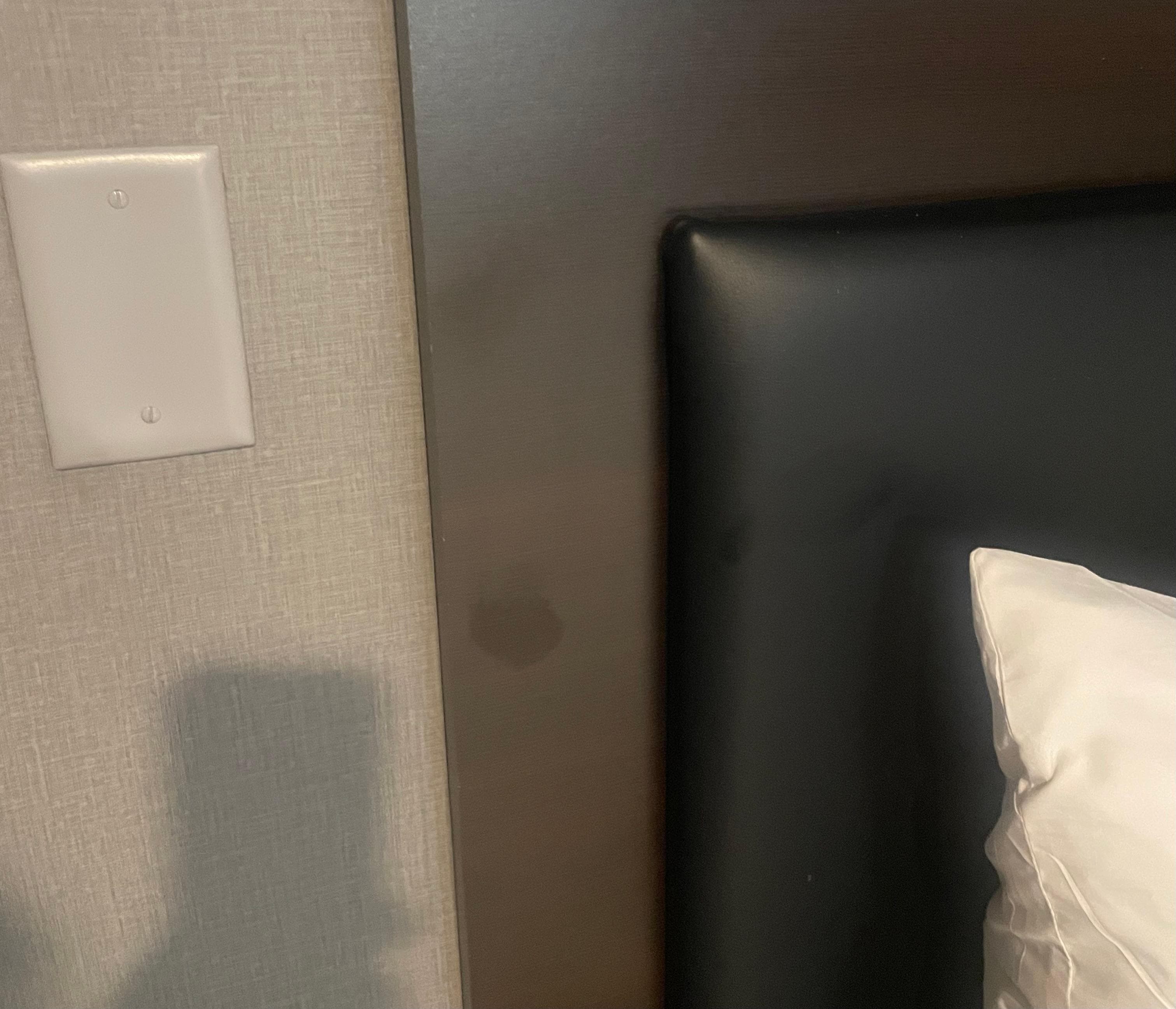 Some type of stain left on headboard right next to butt mark on bed