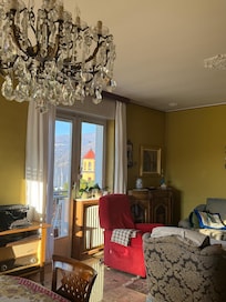 Living from dining room with view out front balcony.