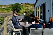 Sitting in front of the cottage playing cards