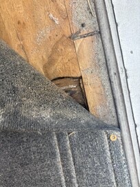 Hole in the floor covered by a carpet nailed to the floor.