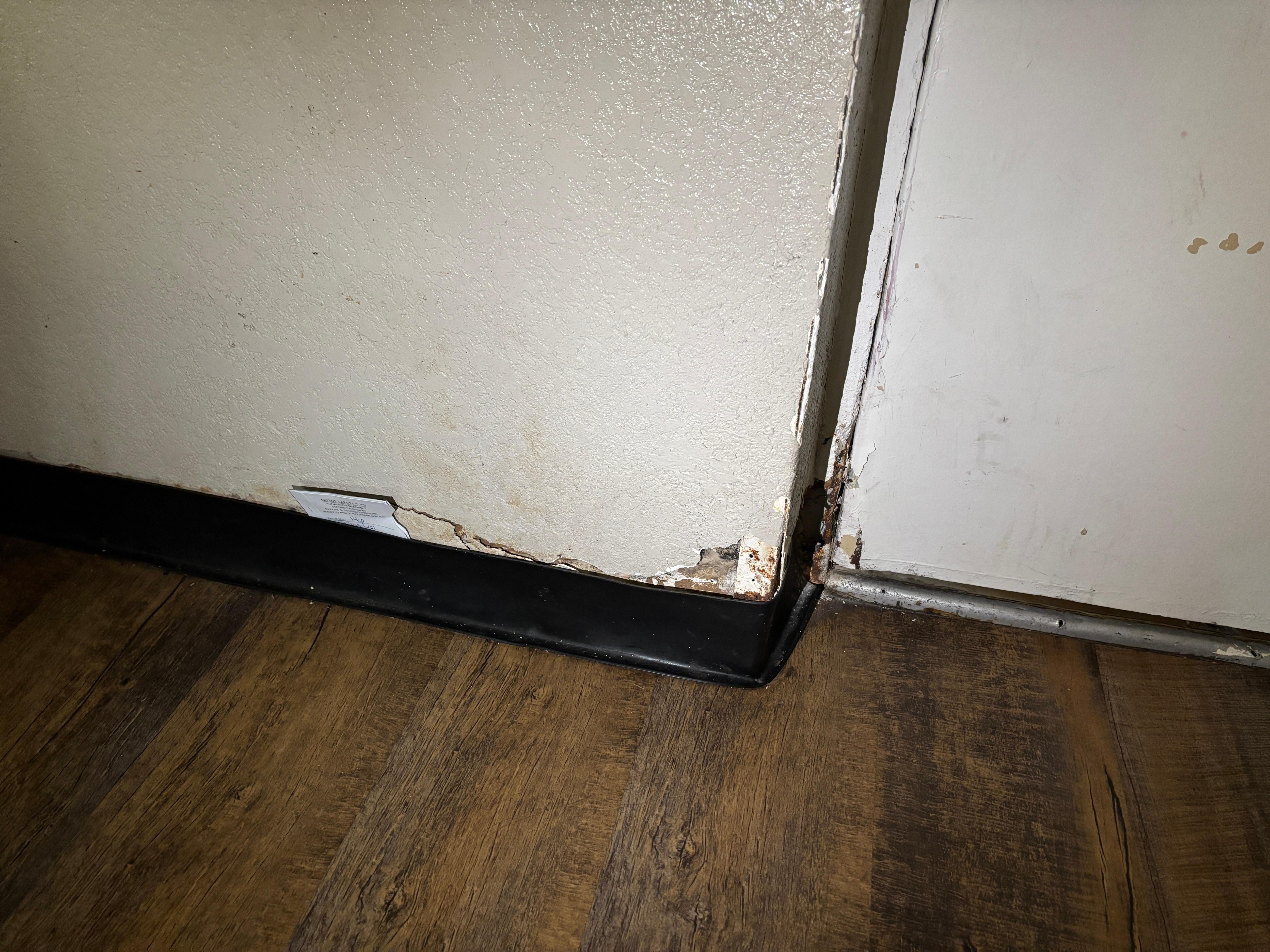 Hole in the door with paper in the wall