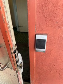 Side door to the hotel, broken, homeless living outside the hotel near this door.