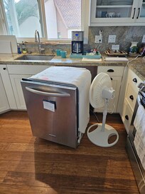 Leaking dishwasher removed and left in kitchen for paying customers to enjoy?