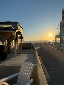 View from front private porch with firepit table & umbrella a nd gas geill