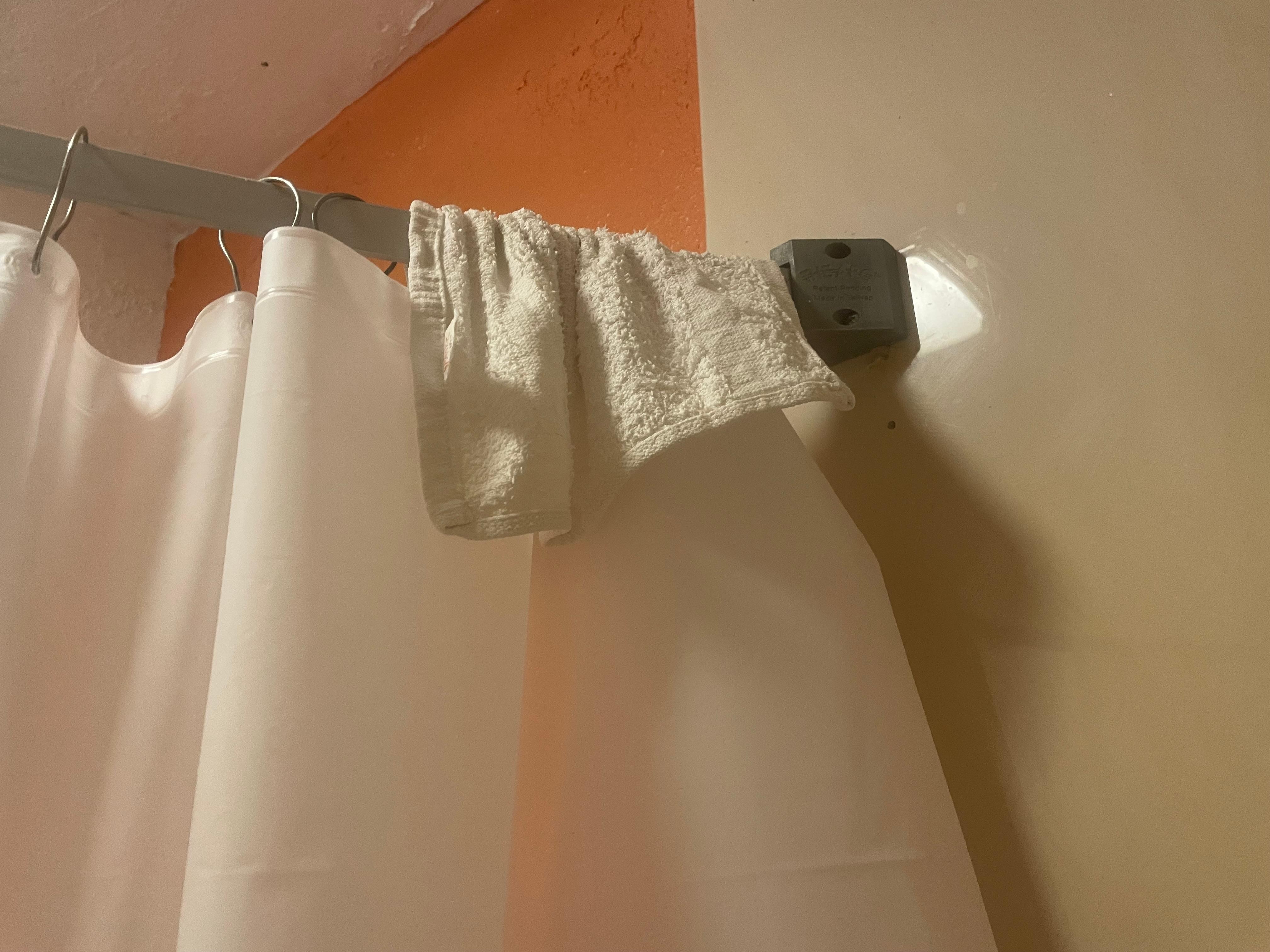 Dirty washcloth on shower bar.