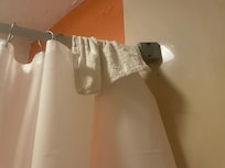 Dirty washcloth on shower bar.