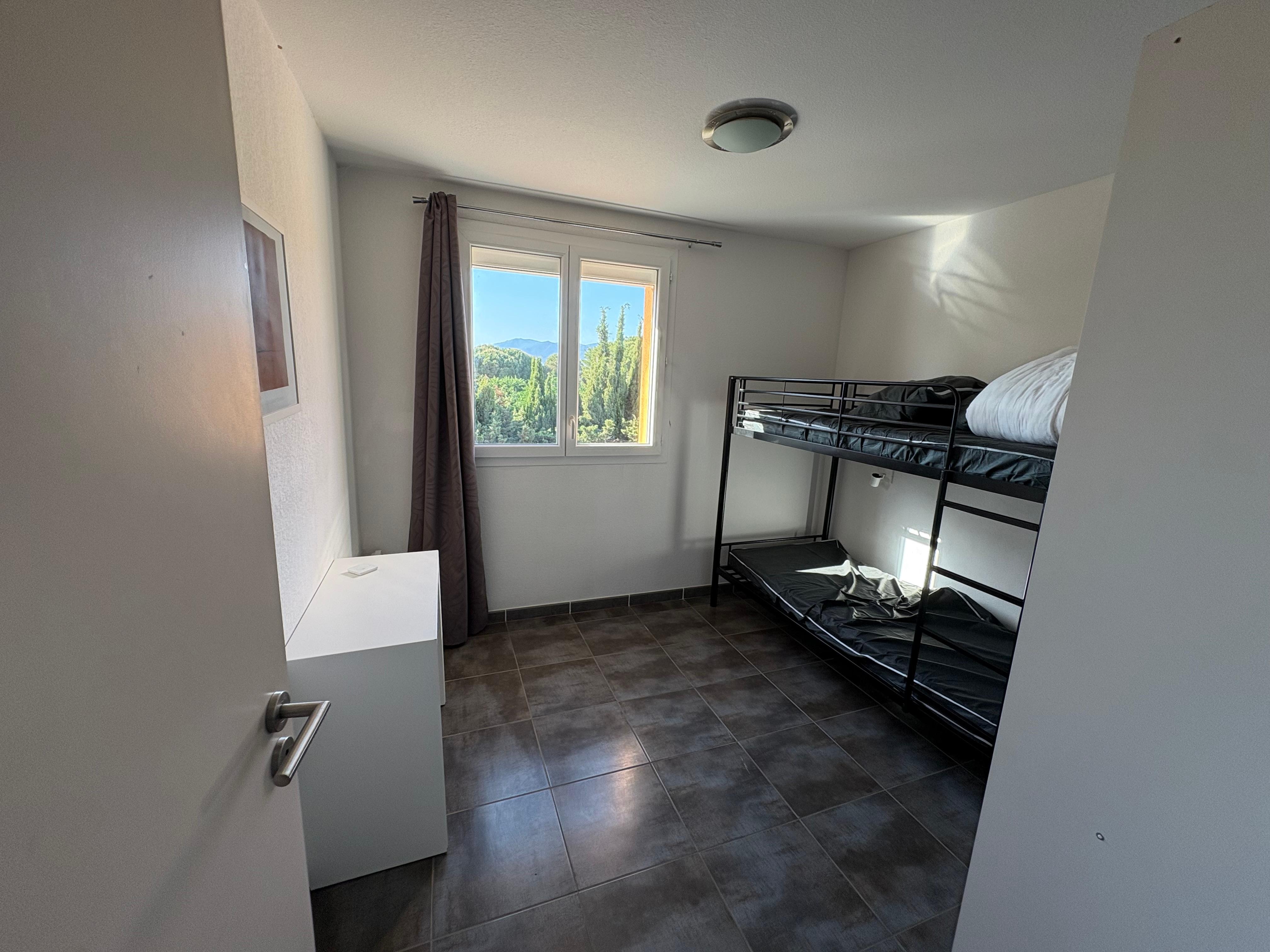 Chambre 1 avec deux couchages superposés d’une personne chacun ainsi qu’un grand dressing et une commode 