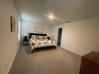 Large & open primary bedroom with a king sized bed.
