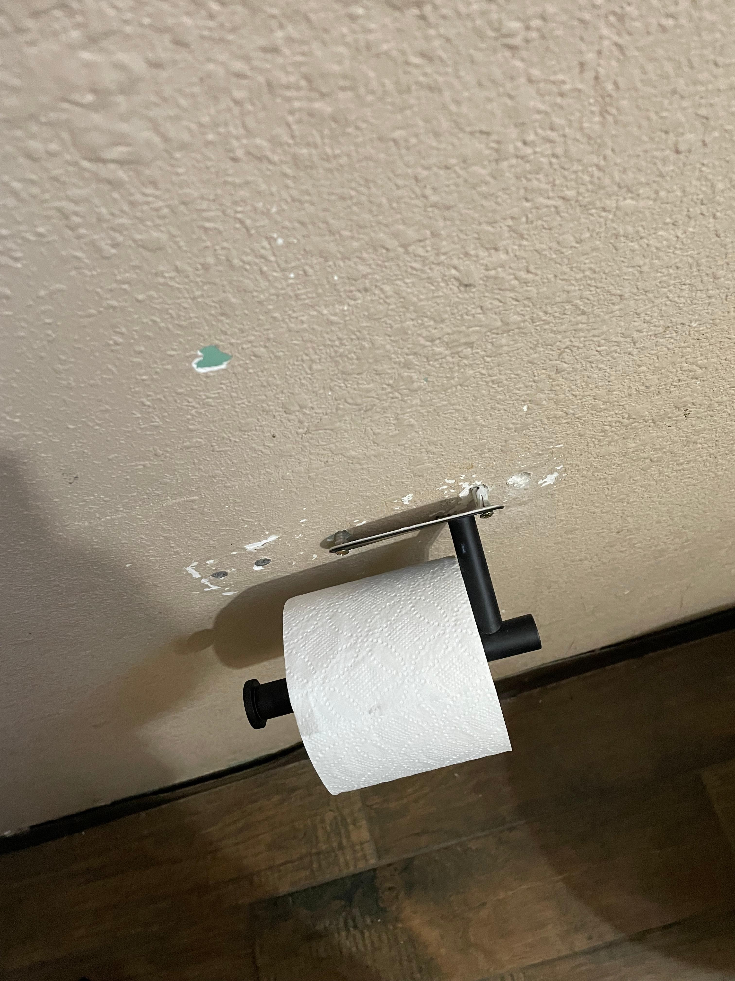 The curtain rods towel racks and paper holder all falling off the wall