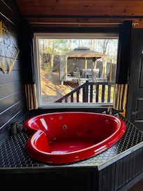Inside jacuzzi view looking at the outside hot tub deck with TV and fire place