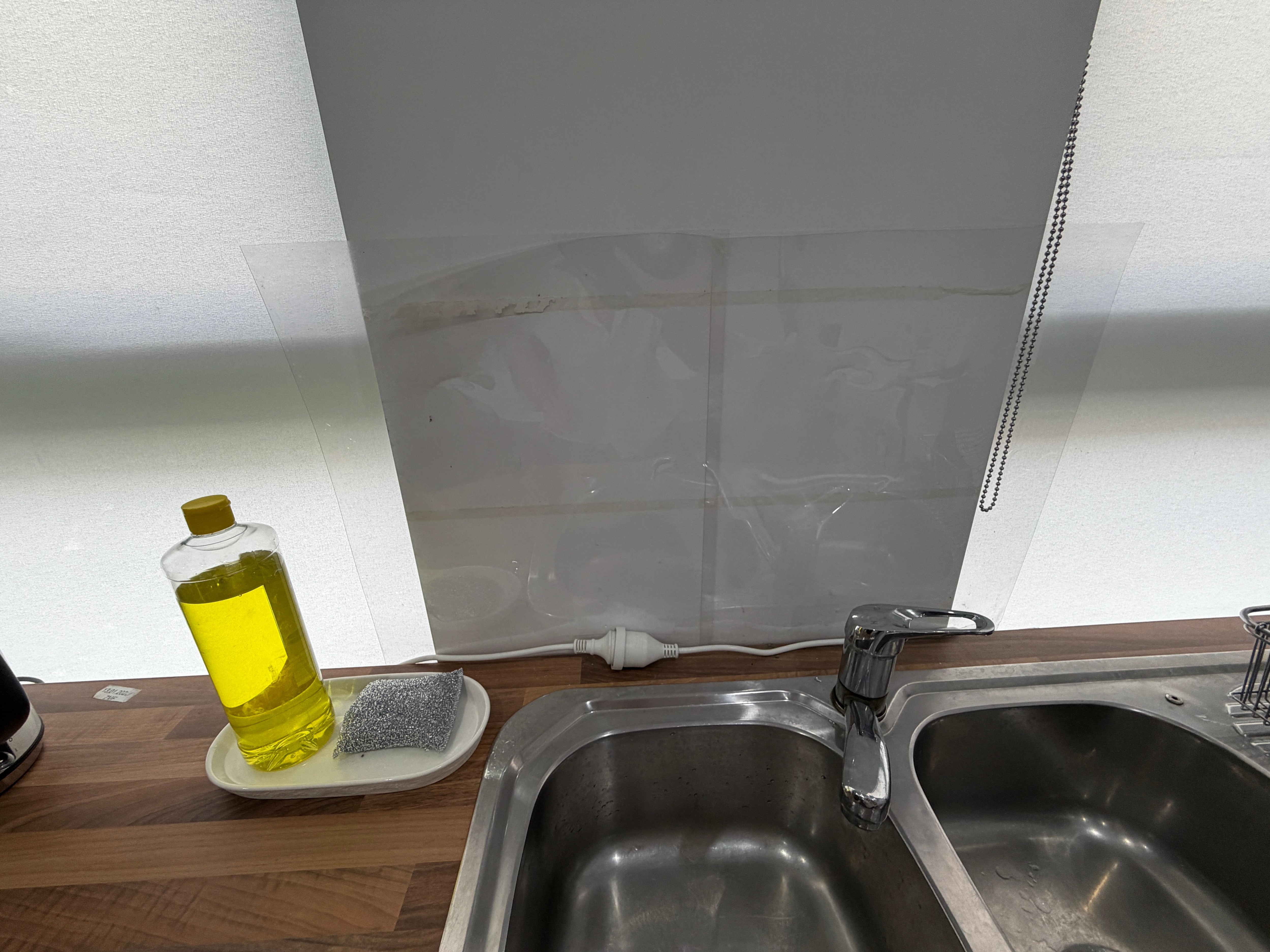 The makeshift backsplash for the kitchen sink.