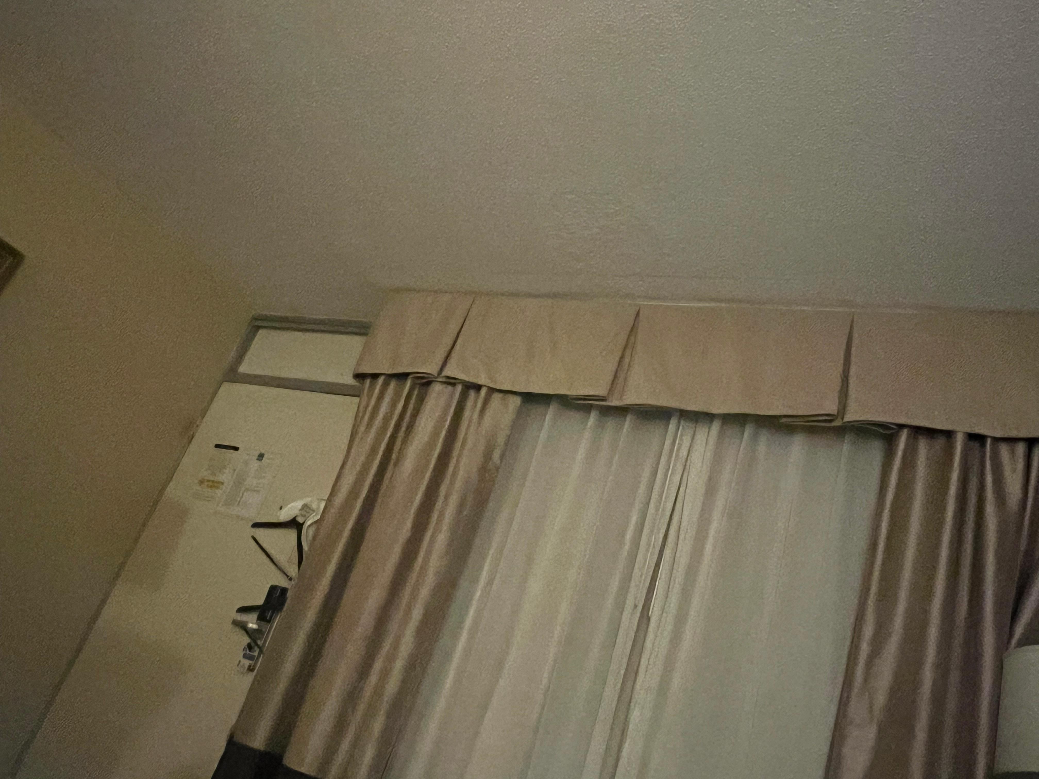 Ceiling damage and super old curtains that aren’t moveable 