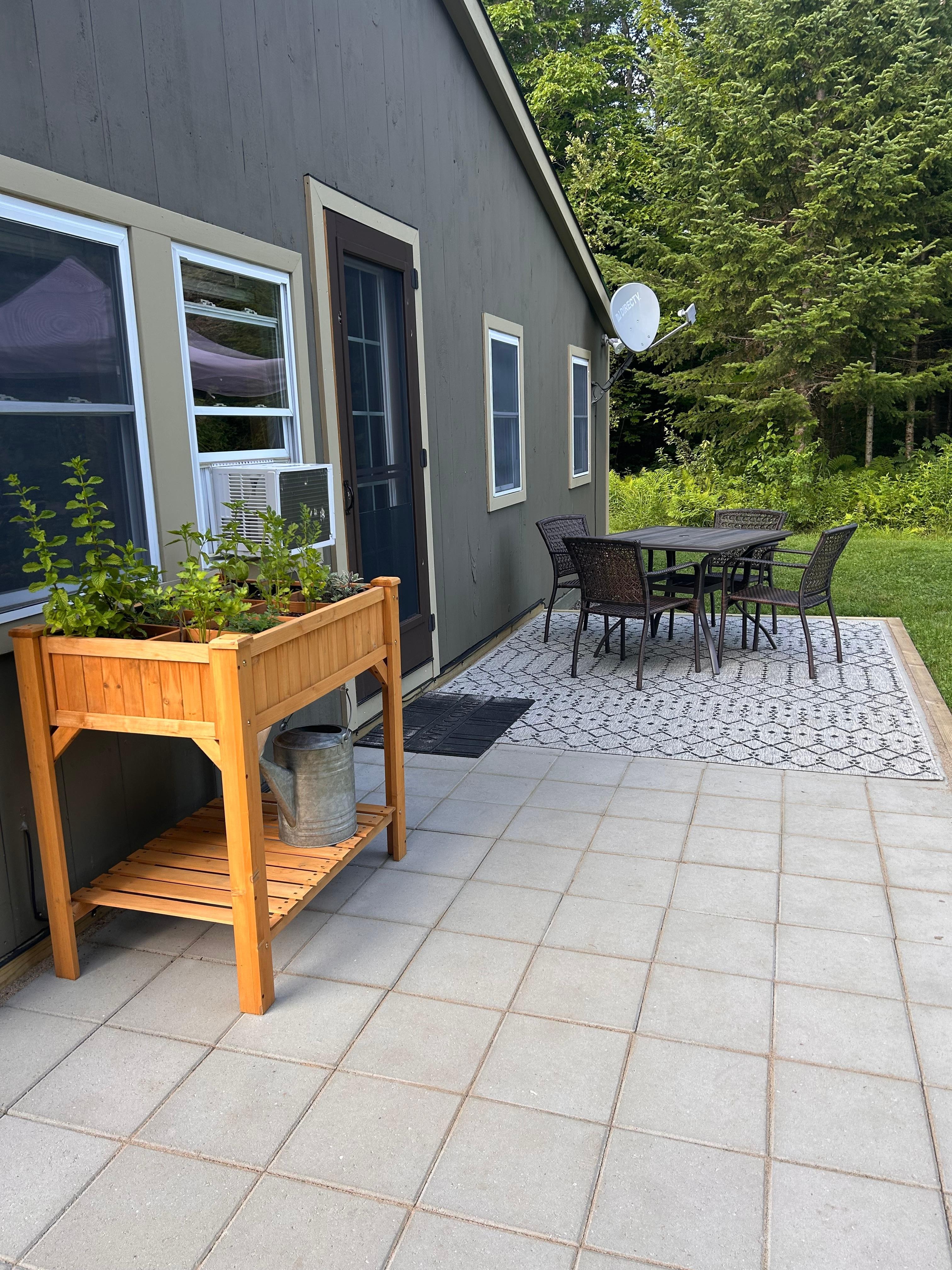 Outside patio area with fresh herbs and cute table set
