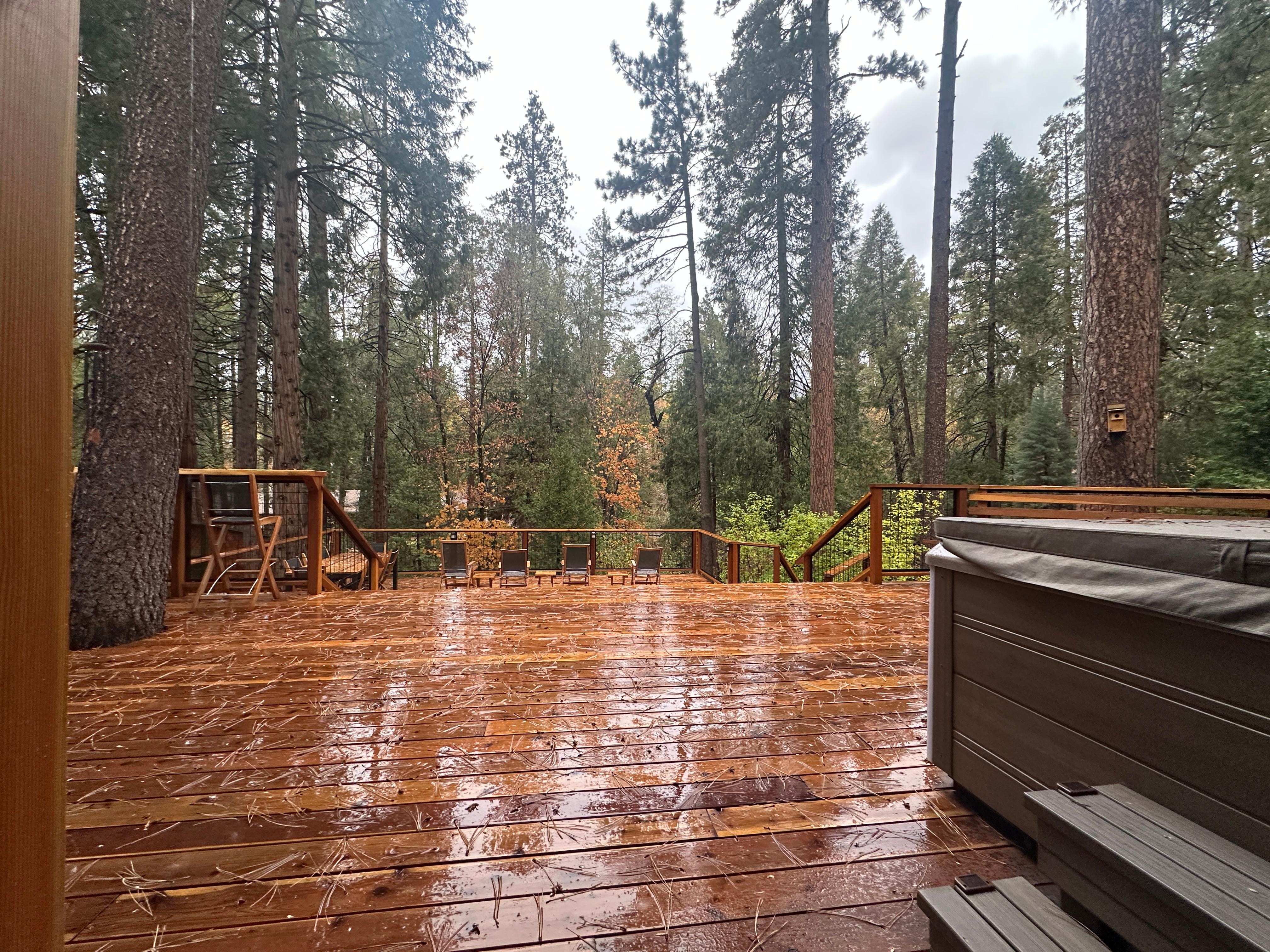 Outdoor deck area with hot tub. 