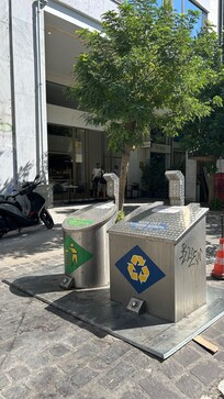 The garbage and recycling bins outside the entrance with bad smell