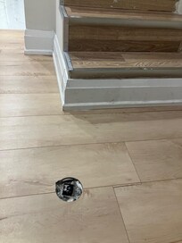 Hole in the floor at bottom of basement stairs.