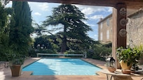 Blick vom überdachten Pool Bereich mit Küche, Tisch, Sofa zum Pool und der beeindruckenden Zeder