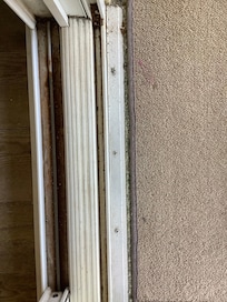 Caked on grime and dirt on both sides of sliding glass doors