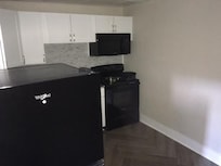The kitchen, with none of the appliance functional and the fridge disconnected and standing in the middle of the room.