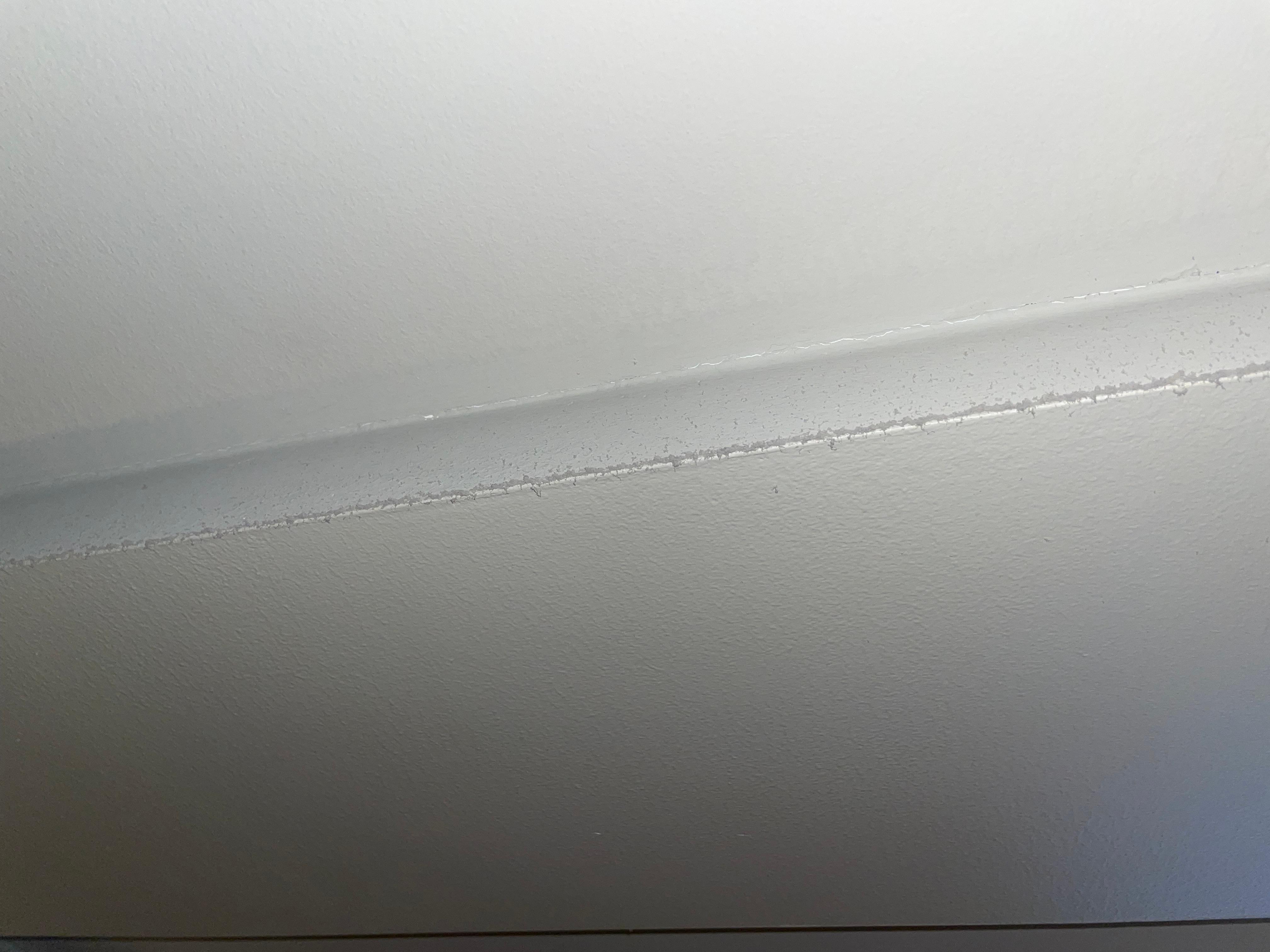 A thick layer of dust on the ceiling opposite the air vent.