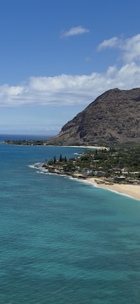 Seen from the top of Lahilahi, Makaha beach is in the back. The building can be seen at the base of the cliff. In front is the end of Papaoneone beach (Princess).