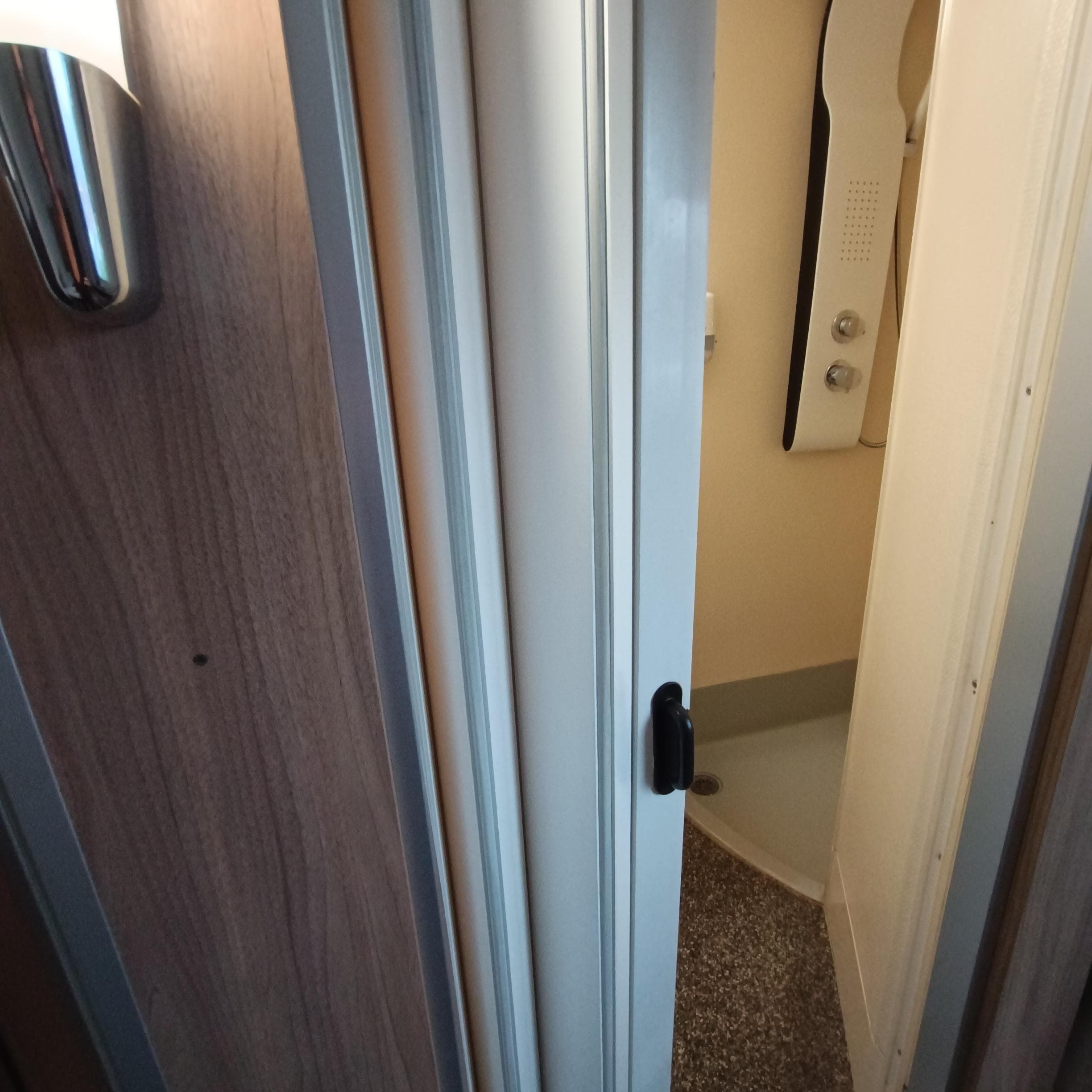 Rideau accordéon servant de porte entre toilettes-salle de bain et chambre