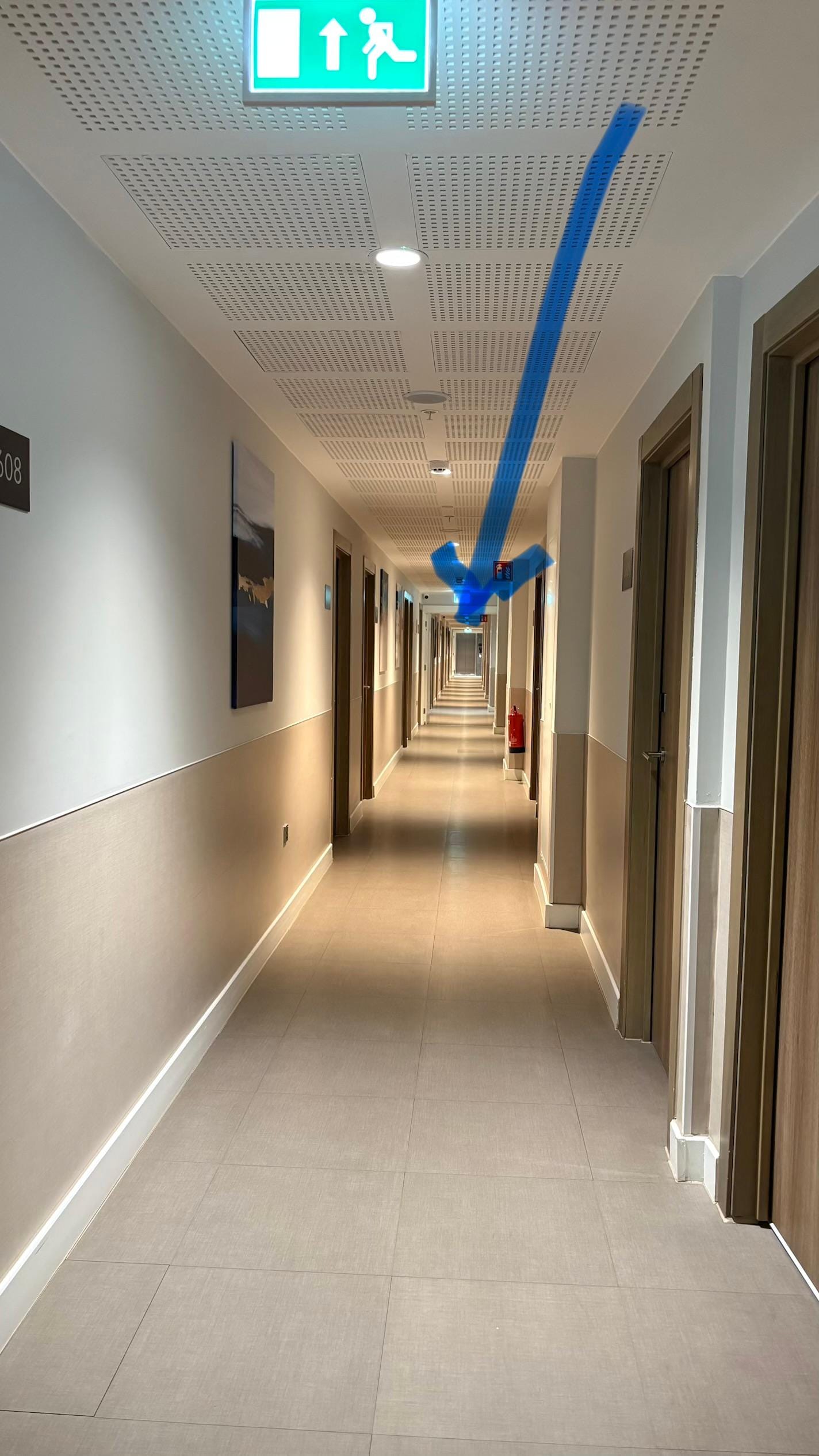 the room is to the left of the elevator door (pointed at the arrow in a secondary hallway)