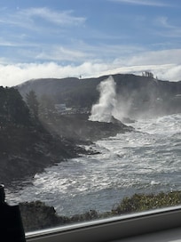 The water spouting as waves crash against the rocks
