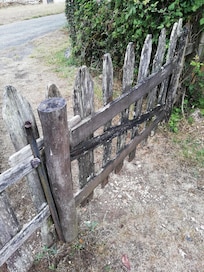 portail d'entrée qui tombe en ruine et qu'il faut soulever pour entrer et sortir