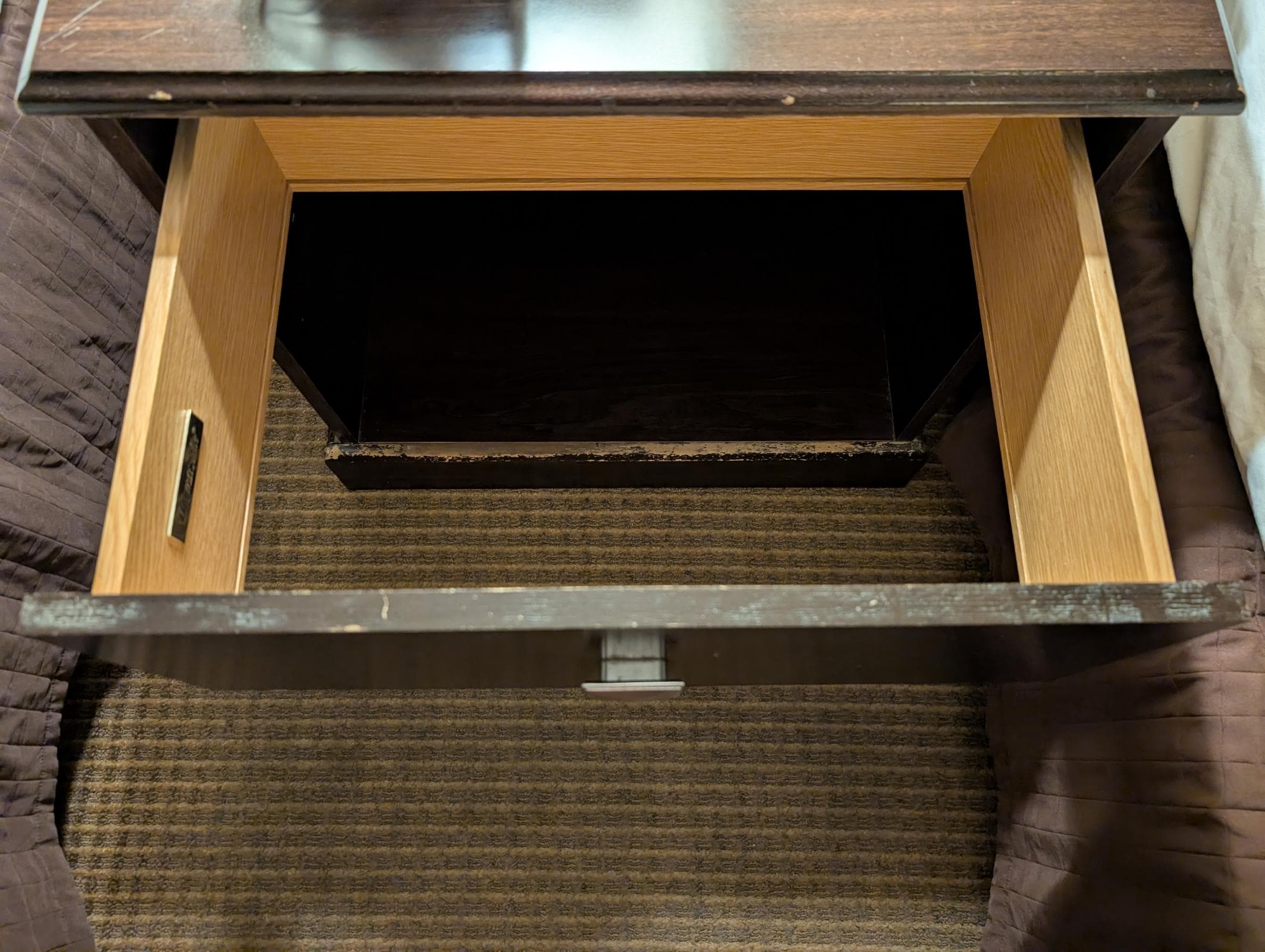 Drawer between beds with no bottom.
