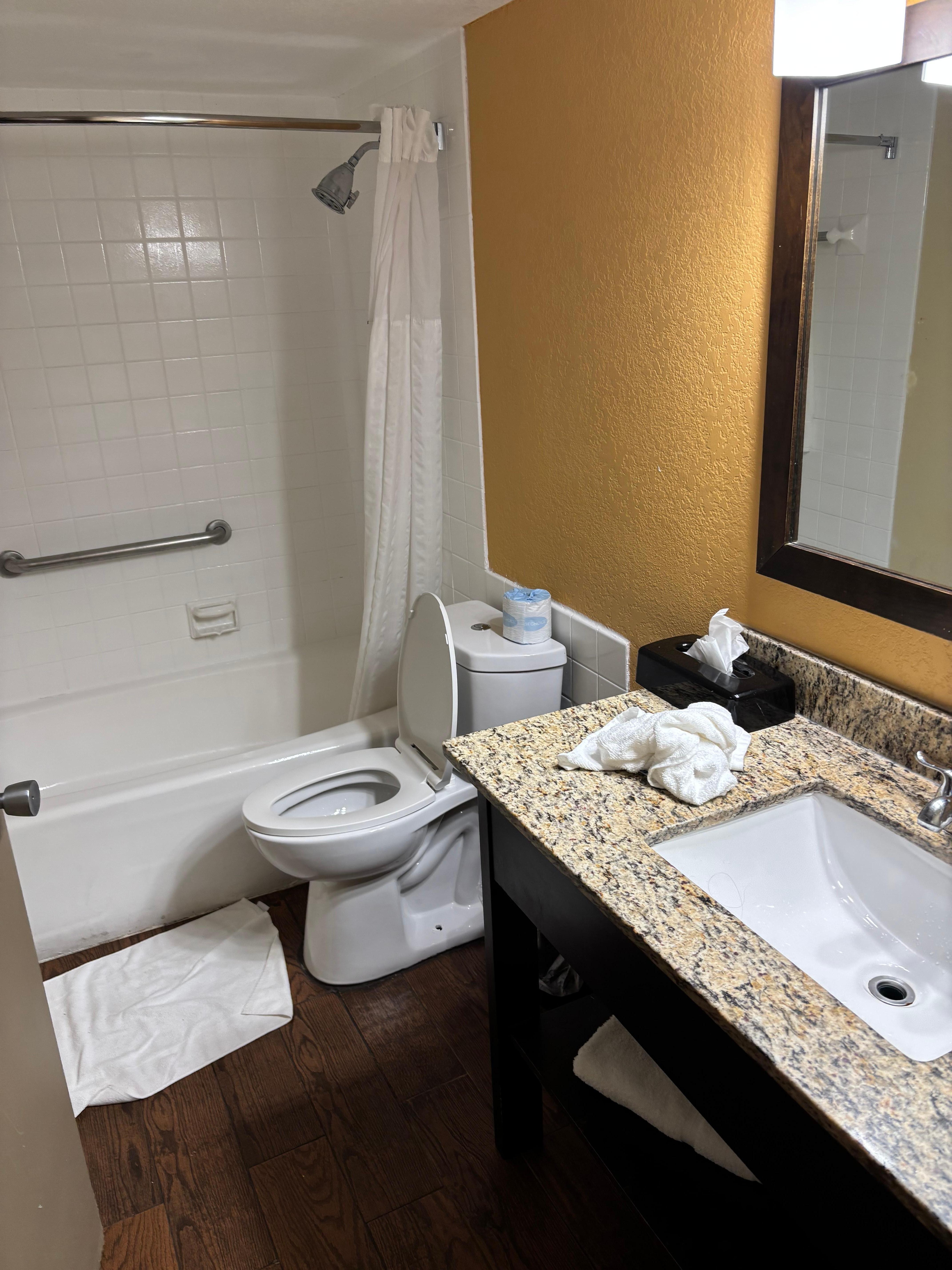 Broken tile on floor of bathroom. Dirty around baseboards.