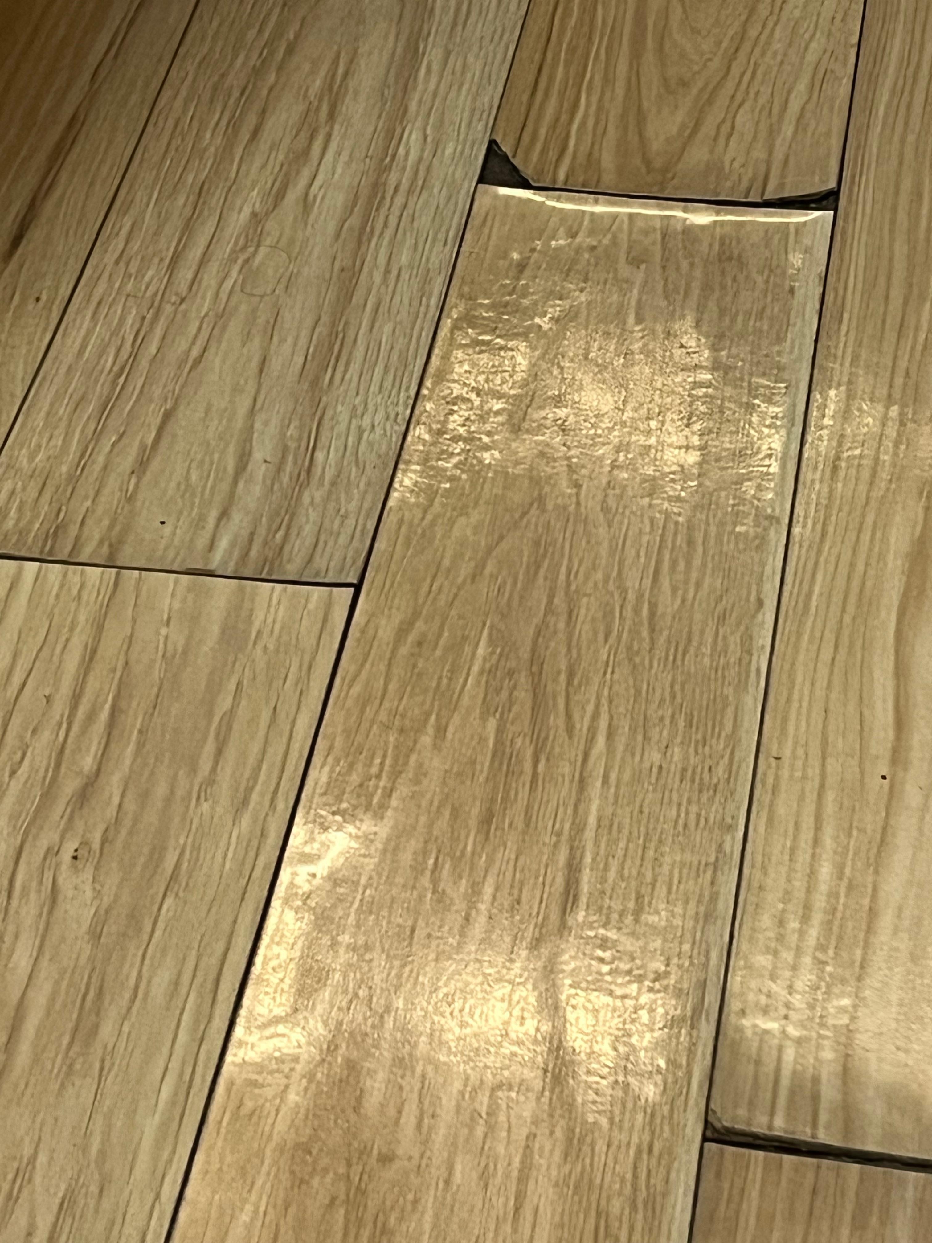 Floor peeling up in main entry to bathroom