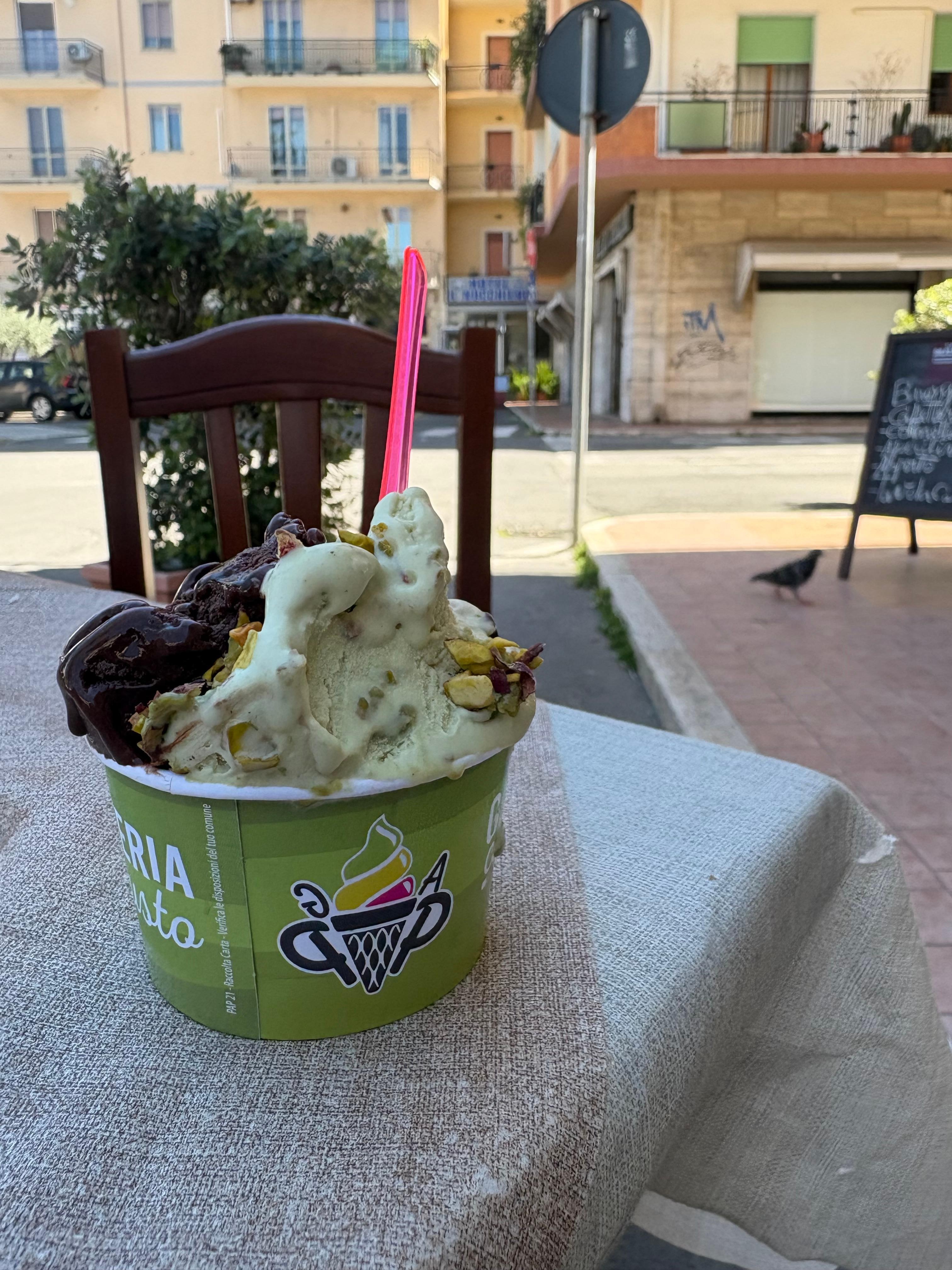 From the bar on the corner, with a gelato from the gelateria three doors down. 