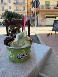From the bar on the corner, with a gelato from the gelateria three doors down.