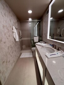 The bathroom is spacious and features a large shower, double sinks, lighted mirrors and automatic motion-sensors lighting especially appreciated when approached in the evening.
