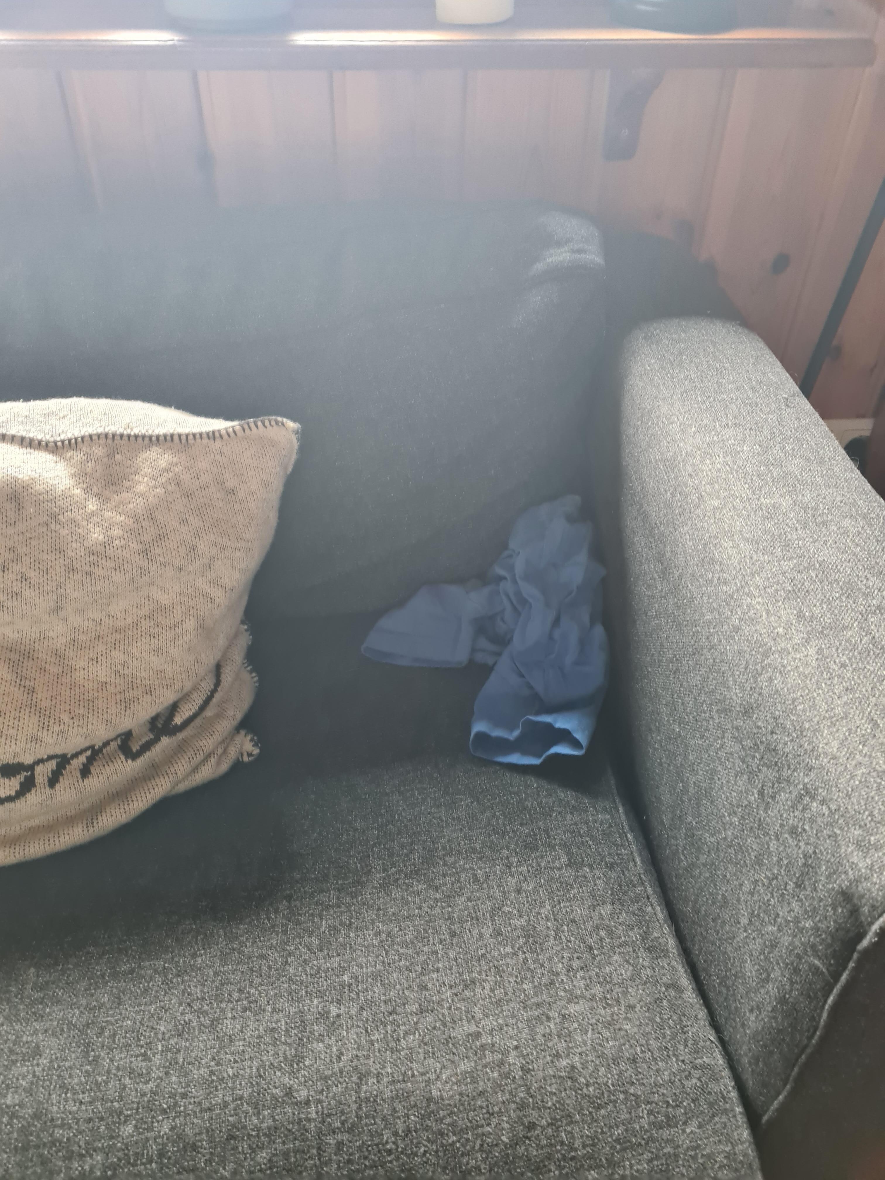 alte Klamotten hinter dem Kissen auf der Couch