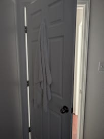 Used towel hung behind the door in one of the rooms