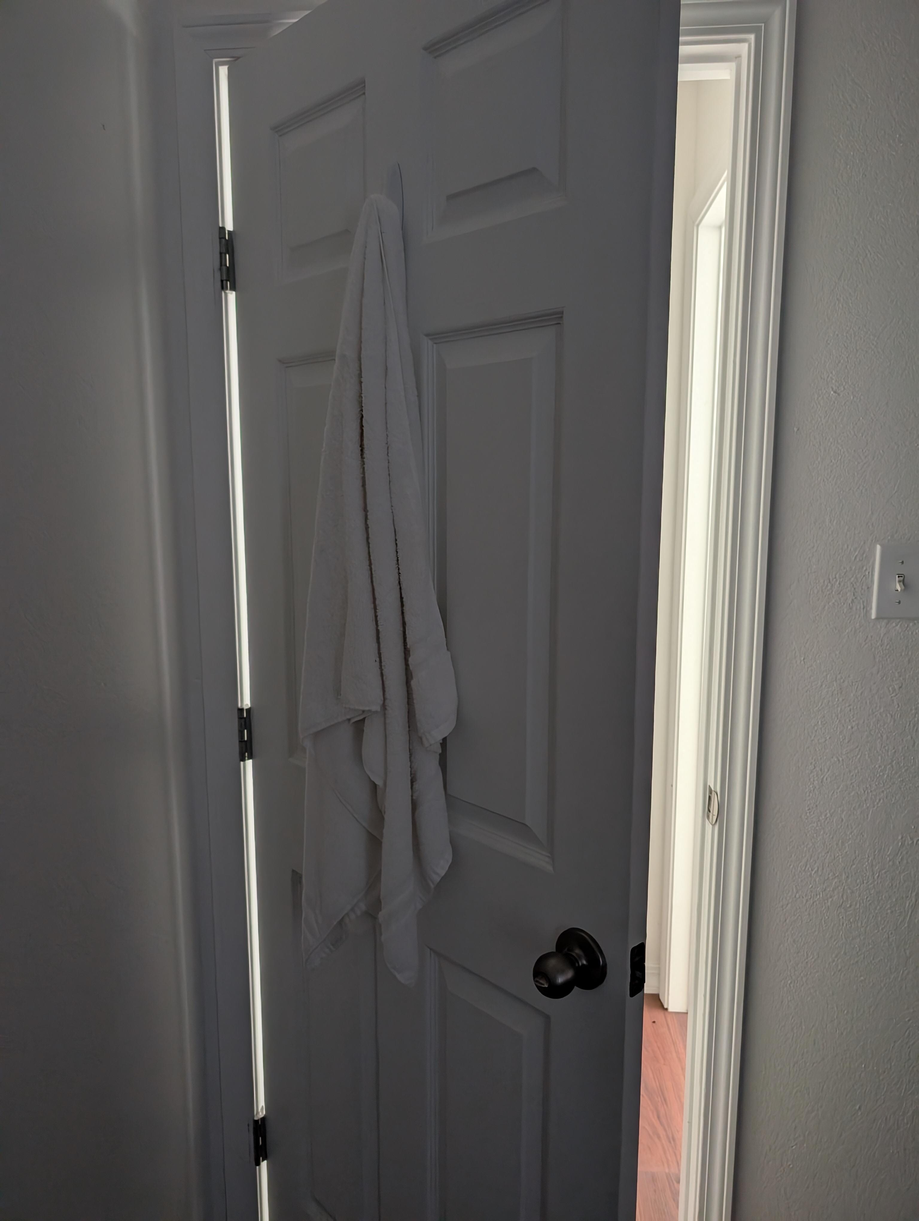Used towel hung behind the door in one of the rooms