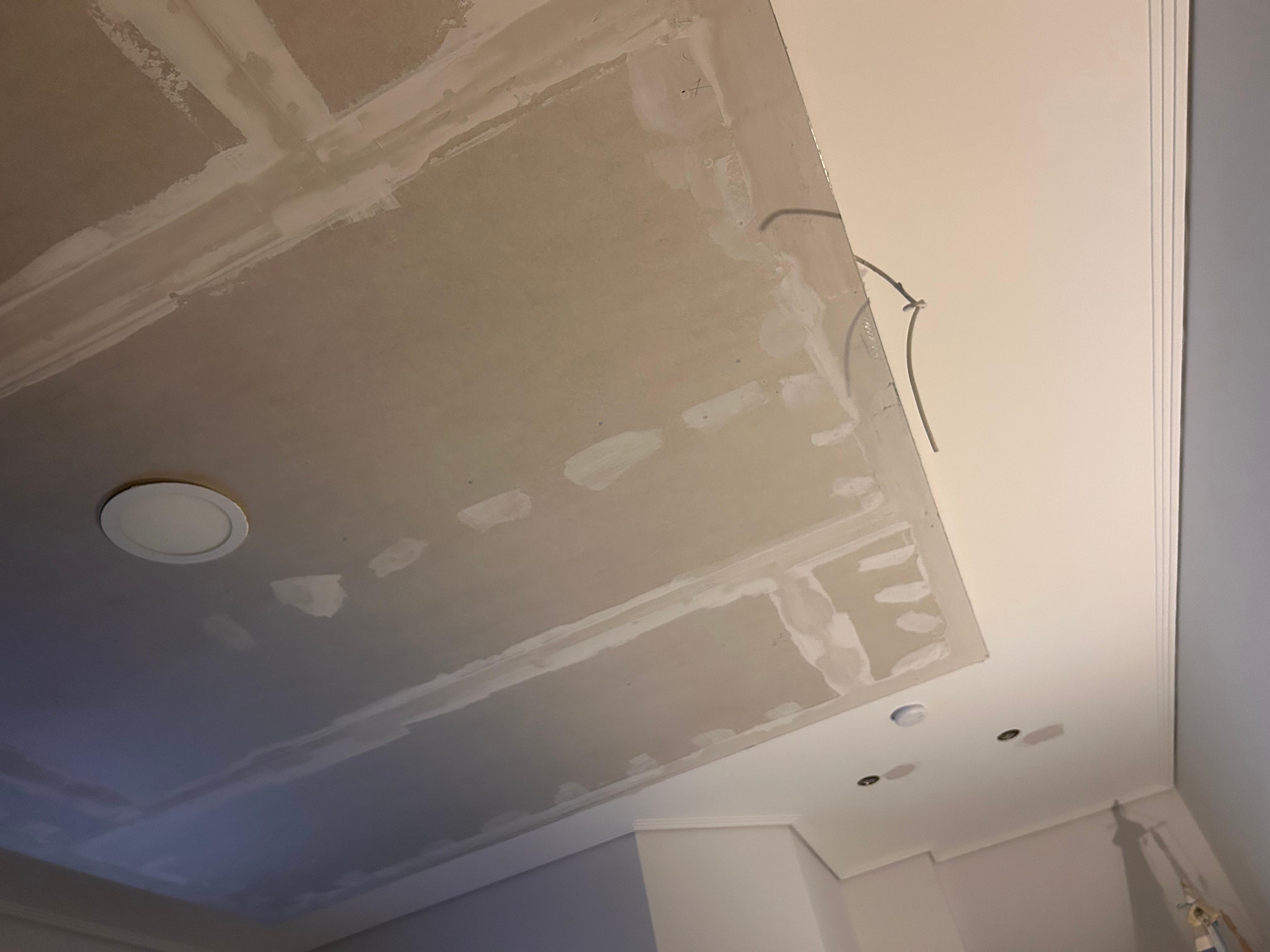 The unfinished ceiling in the bedroom with the loose wire.