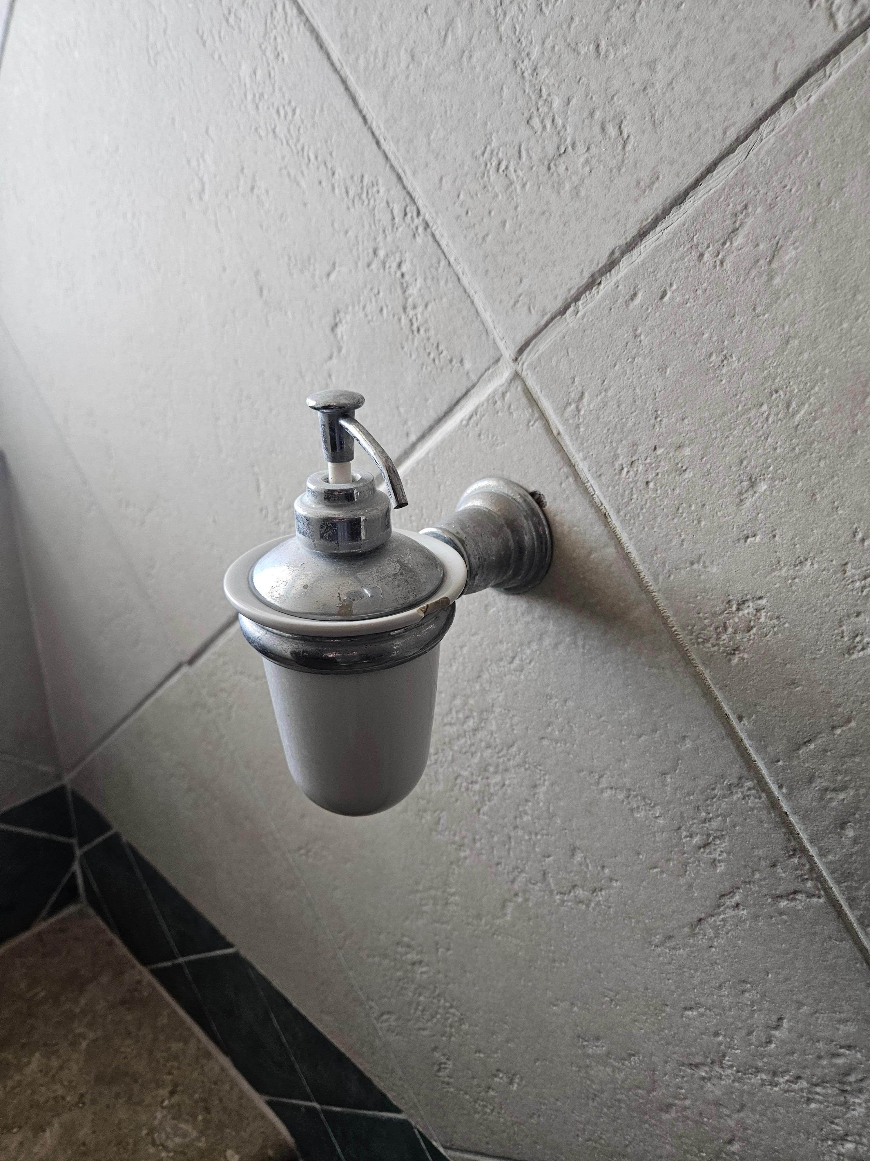 The empty, dated soap dispenser.