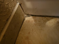 Grime on floor outside of bathtub.