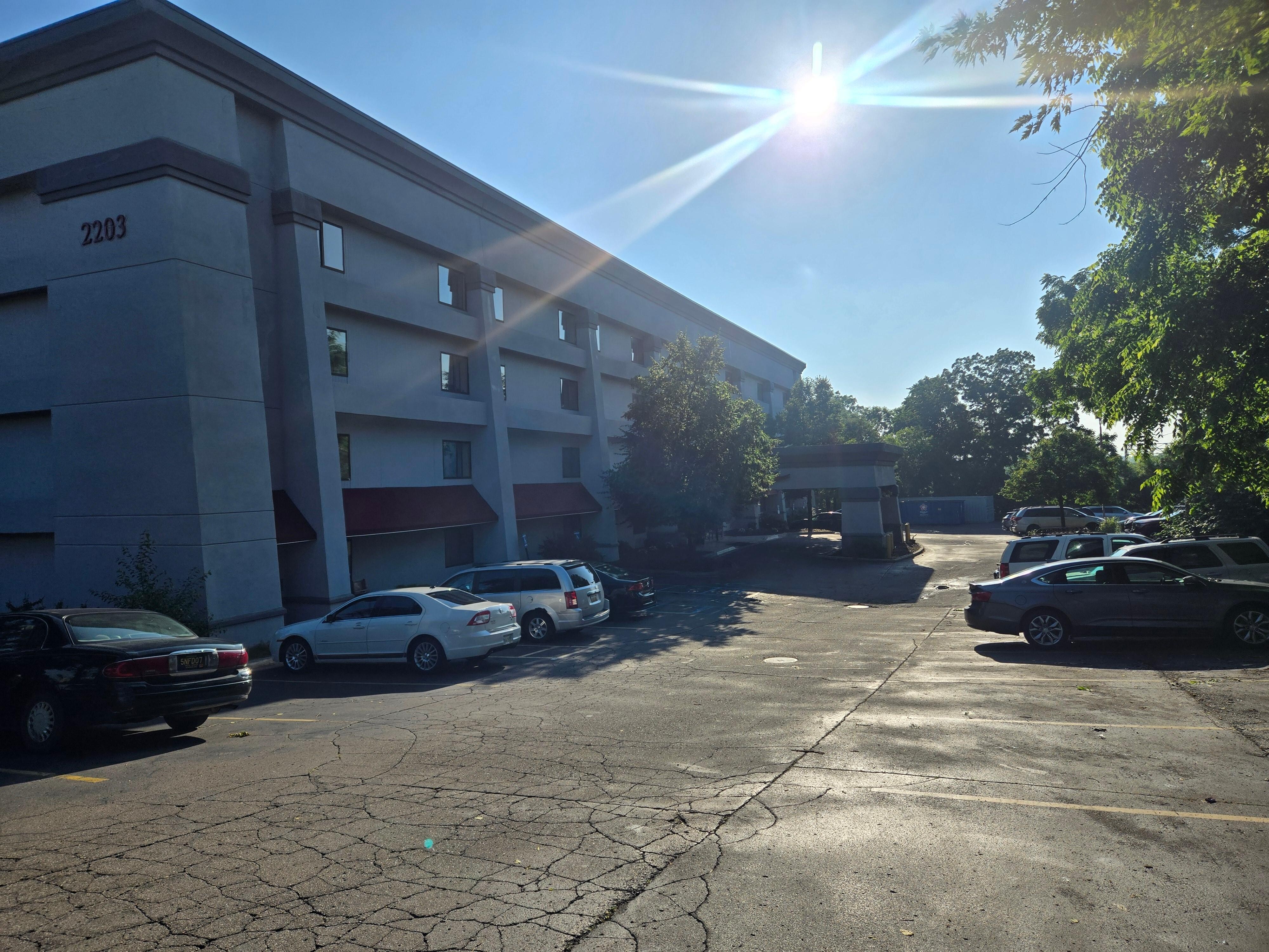 Front of building with an abandoned van in the lot. 