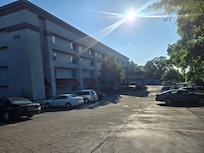 Front of building with an abandoned van in the lot.