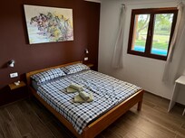 Eines der beiden Schlafzimmer mit Doppelbett, ein drittes Schlafzimmer mit Doppelstockbett vorhanden