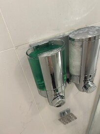Broken shampoo dispenser with missing lid.