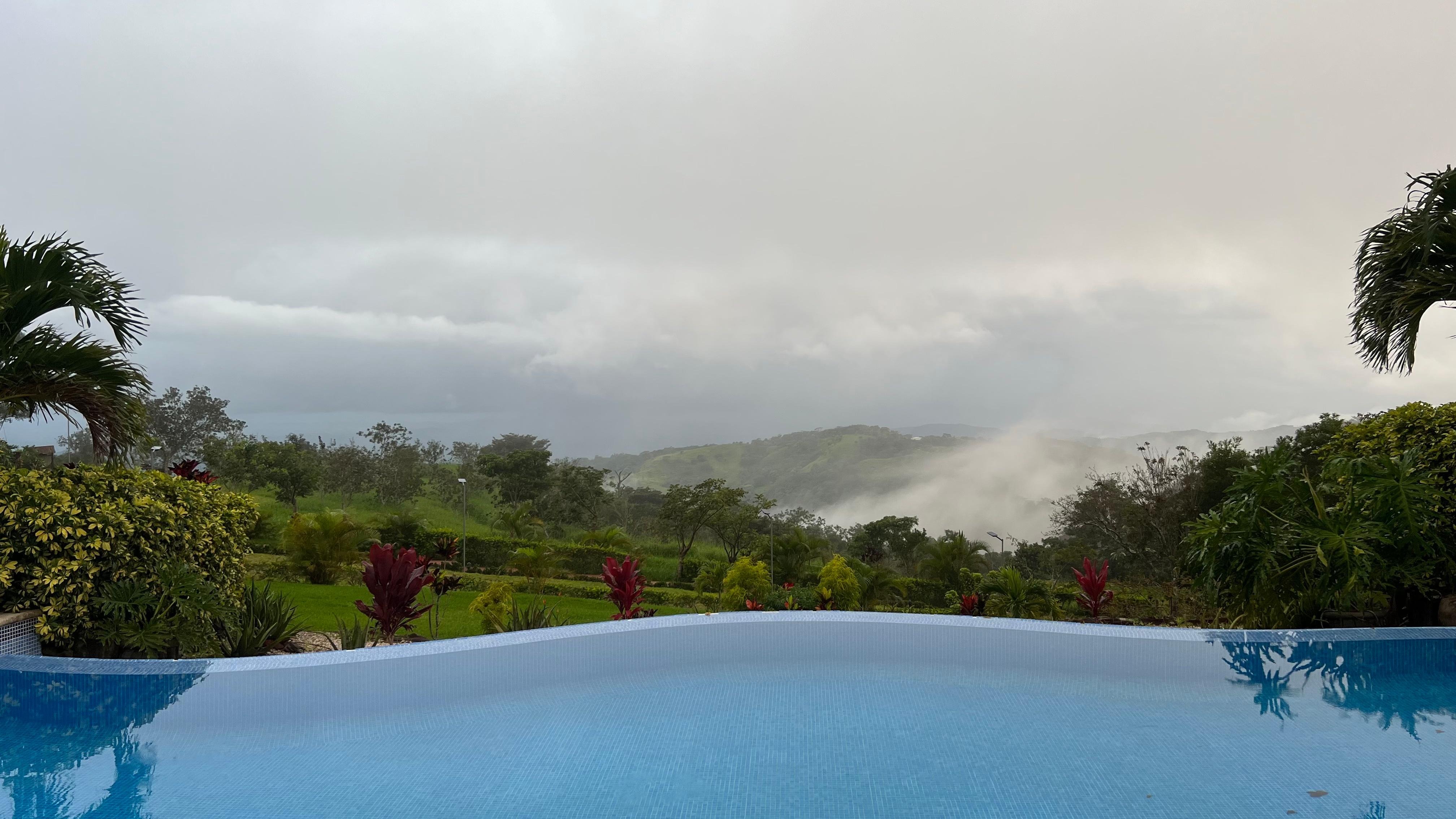 Vista desde la piscina cuando se despeja se logra ver el mar al fondo 