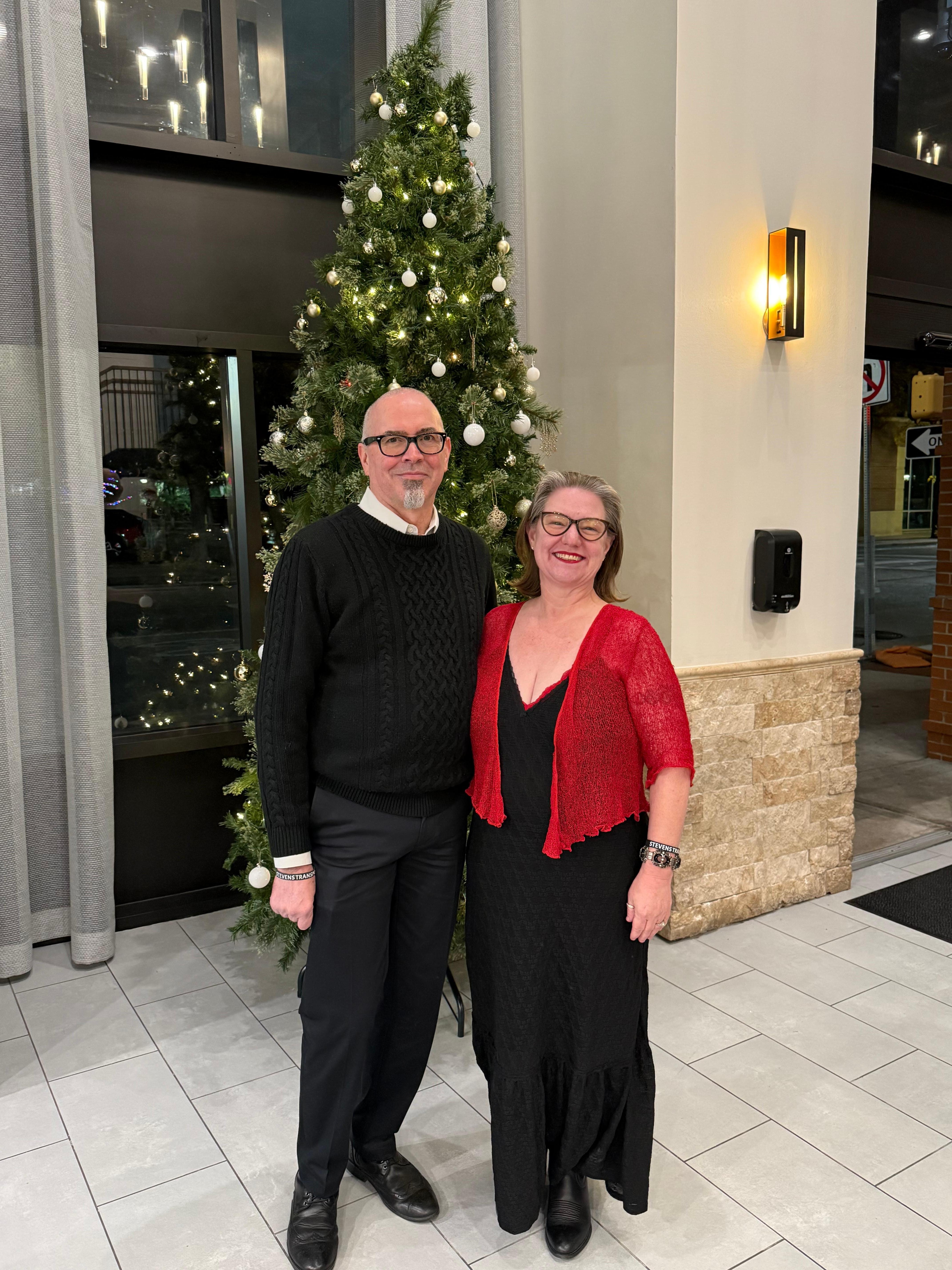 In front of the tree in the lobby.